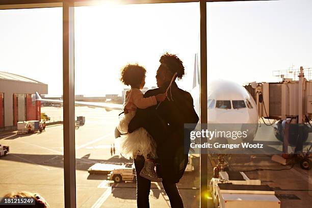 mother holding daughter at airport - curls girl silhouette ストックフォトと画像
