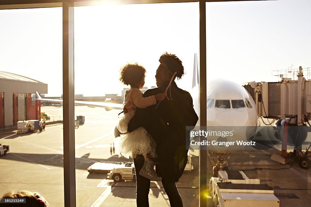 Mother holding daughter at airport