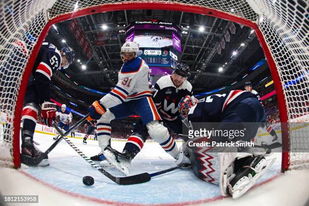 Evander Kane of the Edmonton Oilers scores a goal on goalie Charlie Lindgren and Alexander Alexeyev of the Washington Capitals during the first...