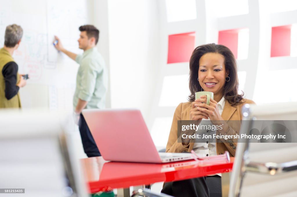 Businesswoman using laptop in office