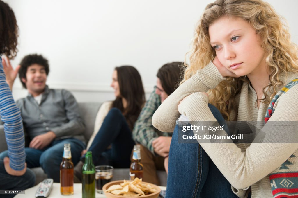Woman sitting apart from friends