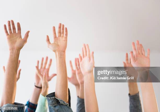 people's hands raised in air - arms raised stockfoto's en -beelden