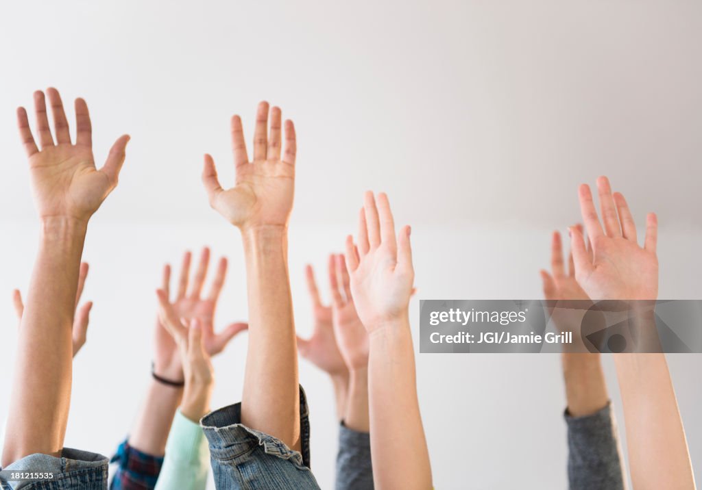 People's hands raised in air