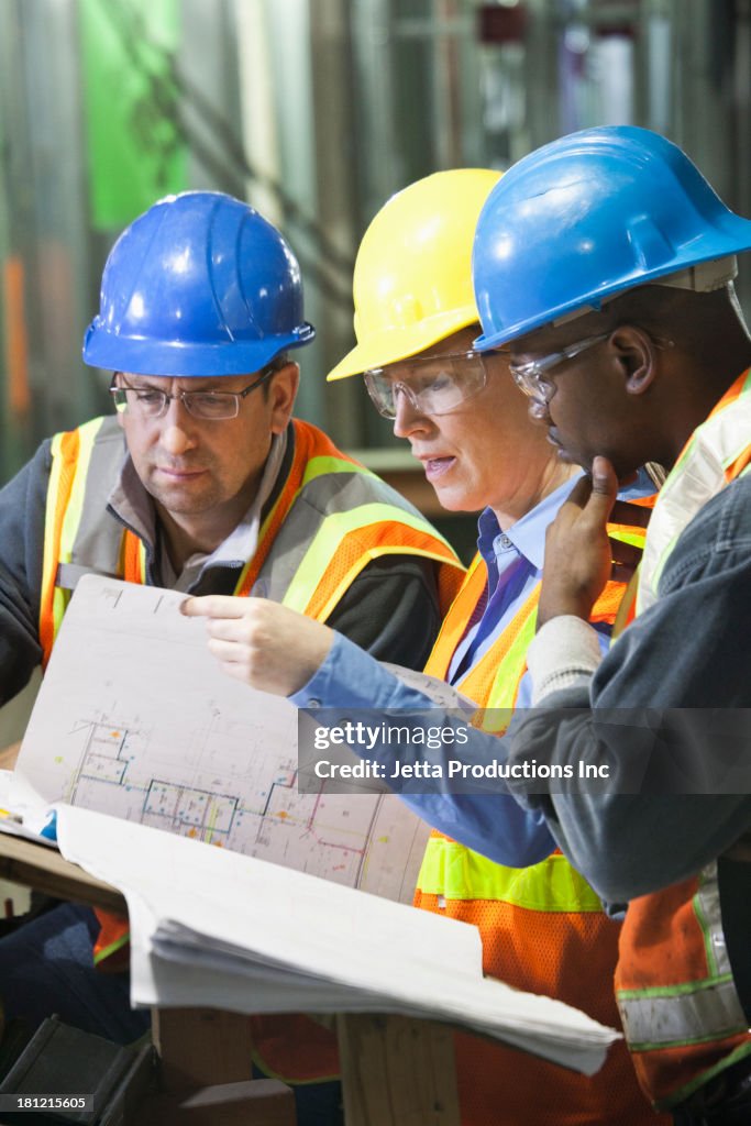 Workers reading blueprints on site