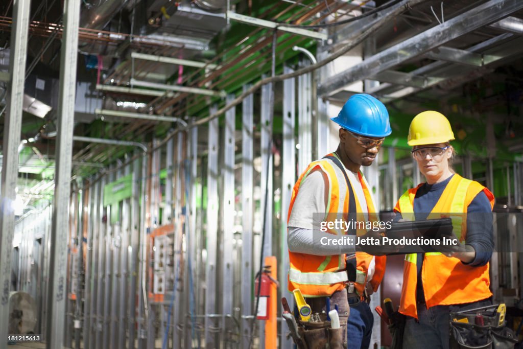 Workers using tablet computer on site