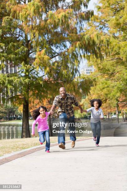 father and daughters playing in park - orlando florida family stock pictures, royalty-free photos & images