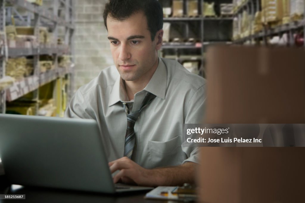 Mixed race businessman working in storage closet