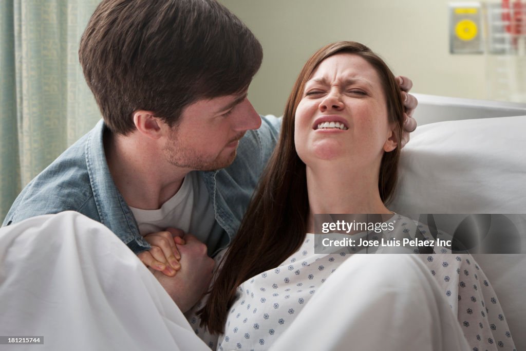 Caucasian man helping girlfriend deliver baby