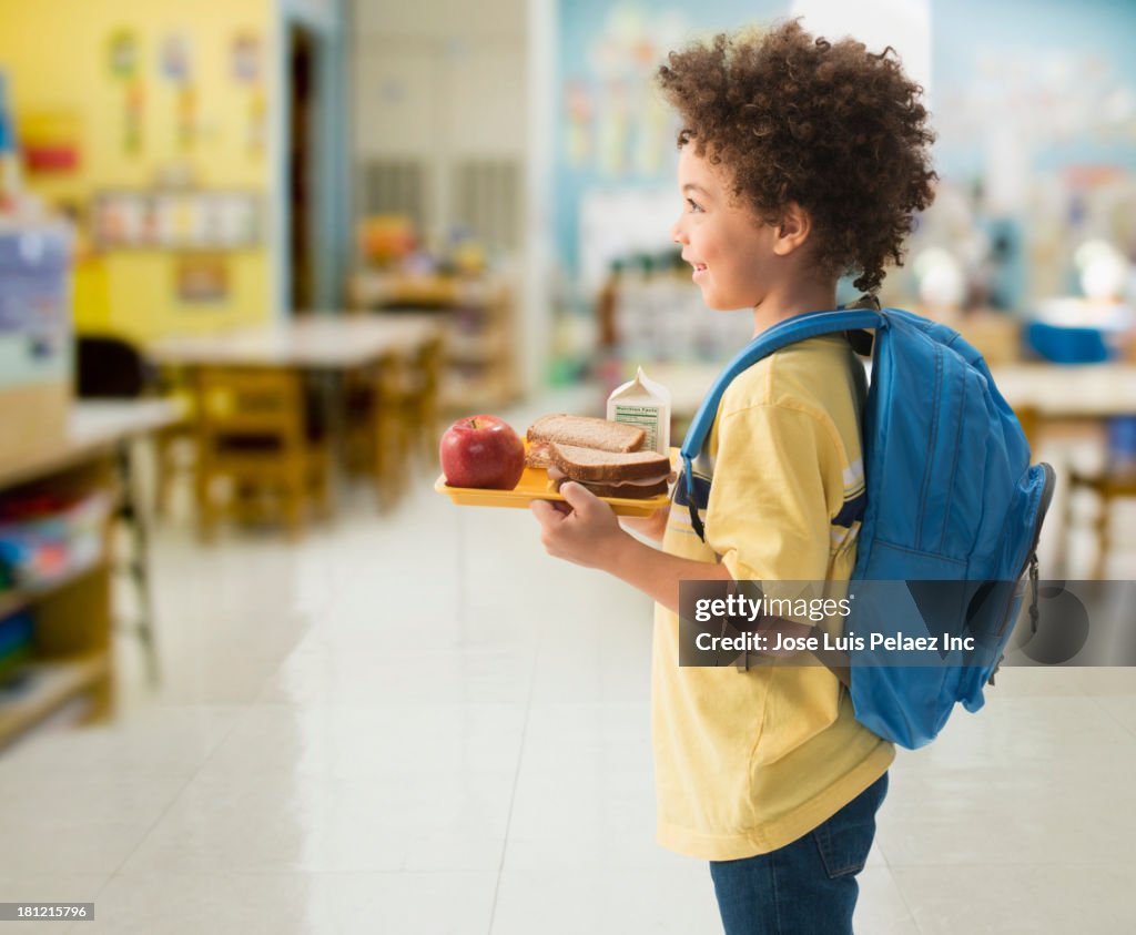 Mixed race boy having lunch at school