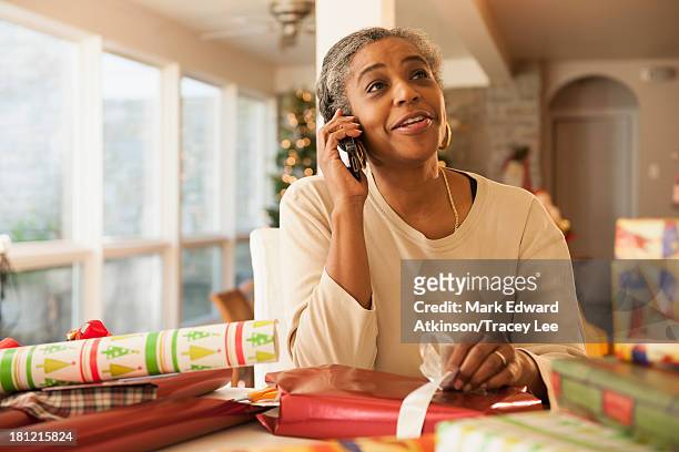 african american woman talking on cell phone - african american christmas images stock-fotos und bilder