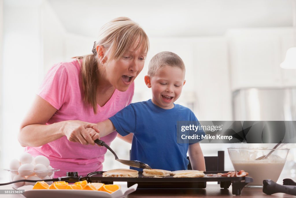 Caucasian mother and son cooking breakfast