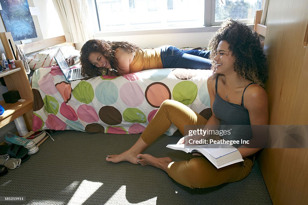 Mixed race college students relaxing in dorm