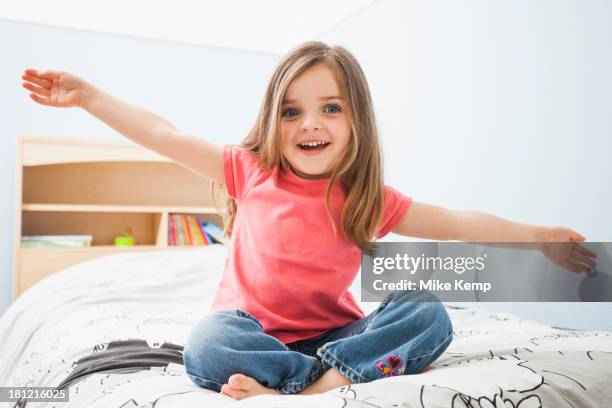 caucasian girl sitting on bed - arm outstretched stock pictures, royalty-free photos & images