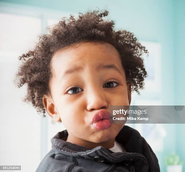 close up of mixed race boy's face - kussmund stock-fotos und bilder