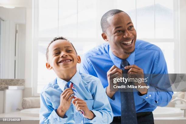 father and son straightening their ties - adjusting necktie stockfoto's en -beelden