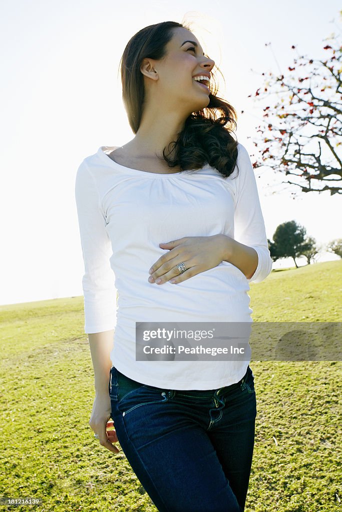 Pregnant mixed race woman holding her belly