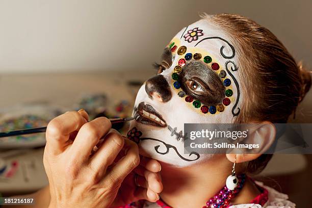 girl having face painted for dia de los muertos - day of the dead 個照片及圖片檔