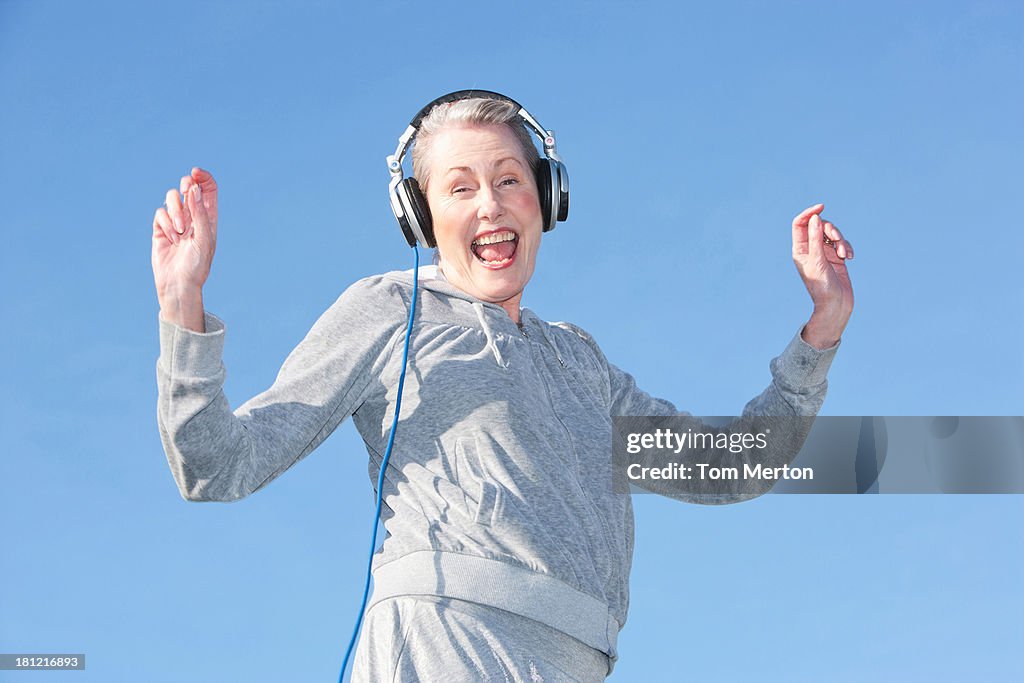 Senior mujer baile y música a través de auriculares