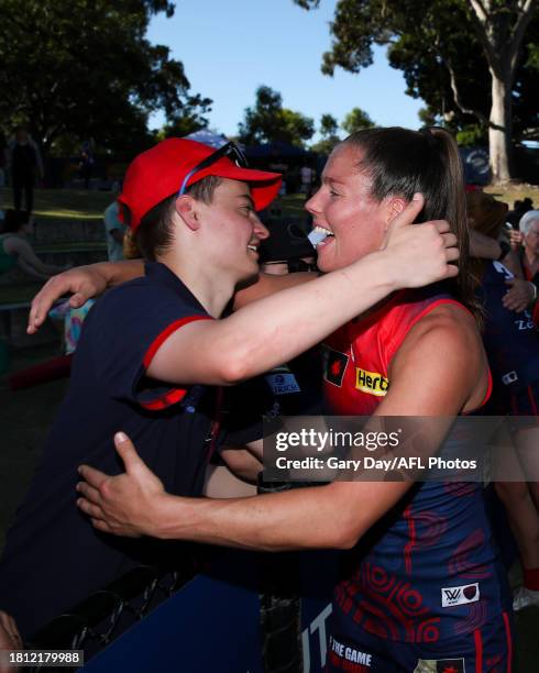 Kate Hore of the Demons celebrates with a fan during the 2023 AFLW Round 07 match between the West Coast Eagles and Naarm at Mineral Resources Park...