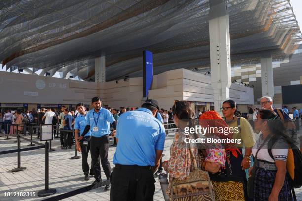 Security workers assist attendees outside the Blue Zone ahead of the COP28 climate conference at Expo City in Dubai, United Arab Emirates, on...