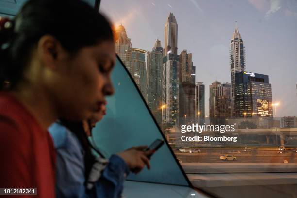 Passengers ride a metro train past skyscraper office buildings in Dubai, United Arab Emirates, on Wednesday, Nov. 29, 2023. More than 70,000...