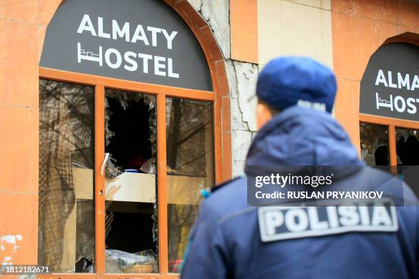 Kazakh law enforcement officer is seen at the site of a hostel fire in Almaty on November 30, 2023. At least 13 people were killed in a hostel fire...