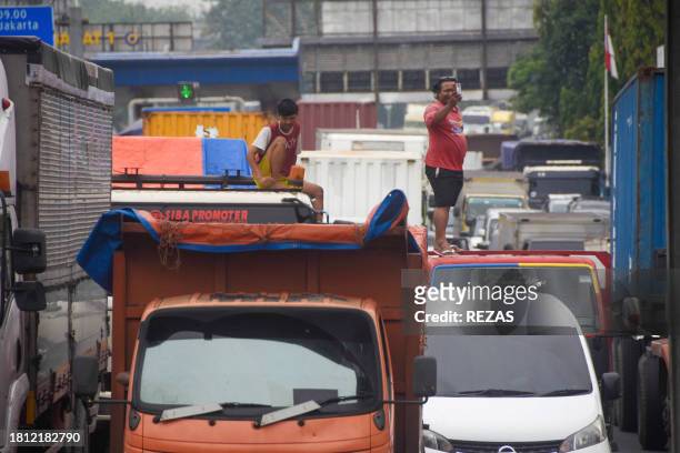 Truck driver takes photos during a traffic jam as activists block traffic during a nationwide strike demanding wage increases, at the Cibitung...