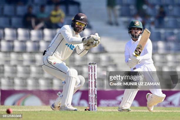Bangladesh's Mominul Haque plays a shot as New Zealand wicketkeeper Tom Blundell looks on during the third day of the first Test cricket match...