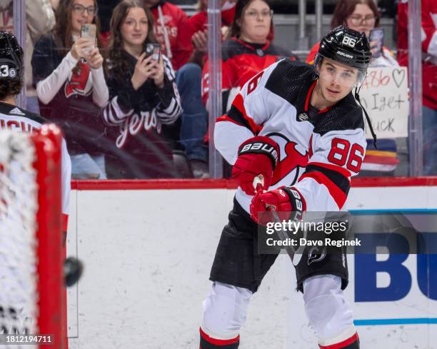 Jack Hughes of the New Jersey Devils shoots the puck in warm ups before the game against the Detroit Red Wings at Little Caesars Arena on November...