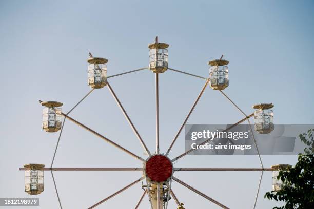 front view of a large ferris wheel in a public park without people with the sky in the background - ferris wheel in spanish stock pictures, royalty-free photos & images