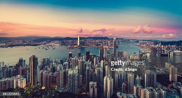 sunset over city skyline and victoria harbour - hongkong stockfoto's en -beelden