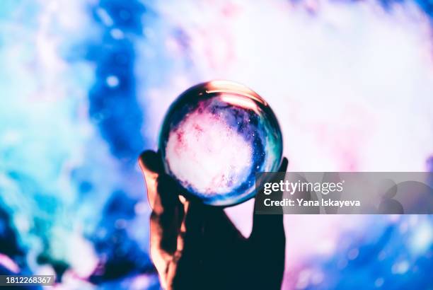 gazing through a cosmic clarity crystal ball - practical magic stock pictures, royalty-free photos & images