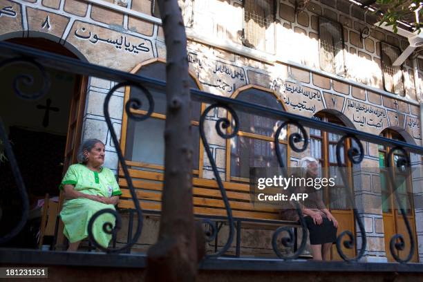 Syrian Christian women sit on a bench in the courtyard of Mar Elias House, a church hostel for the indigent in the old City of Aleppo, on September...
