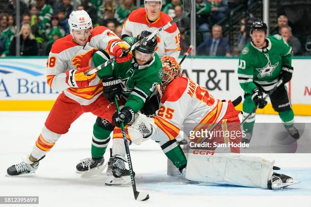 Sam Steel of the Dallas Stars compete for the puck with Dennis Gilbert and Jacob Markstrom of the Calgary Flames during the first period at American...