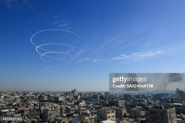 Contrails from an Israeli fighter aircraft line the the skies over Rafah on the southern Gaza Strip on November 30 following the announcement of an...