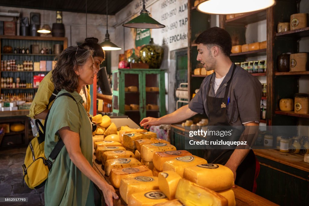 Two tourist women discovering gastronomic market of local products