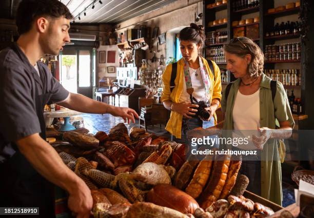 two tourist women discovering gastronomic market of local products - buenos aires market stock pictures, royalty-free photos & images