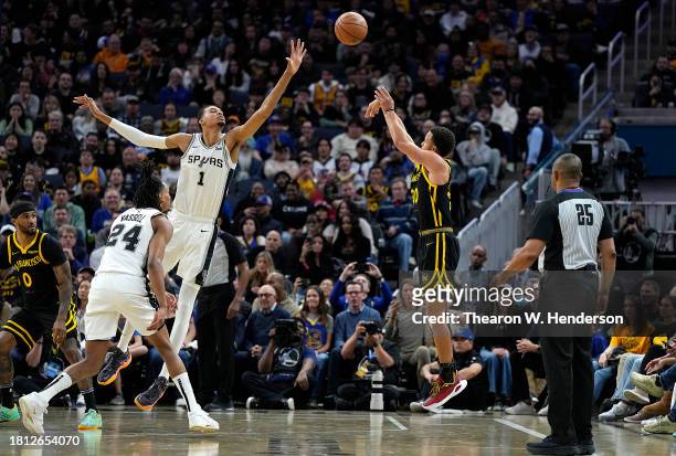 Stephen Curry of the Golden State Warriors shoots a three-point shot over Victor Wembanyama of the San Antonio Spurs during the fourth quarter of an...
