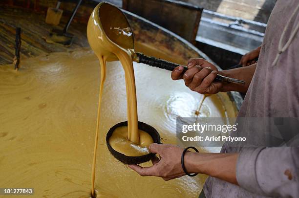 Workers making brown sugar in a small factory in Slumbung village. Most Indonesian people use brown sugar to sweeten foods and beverages. Brown sugar...