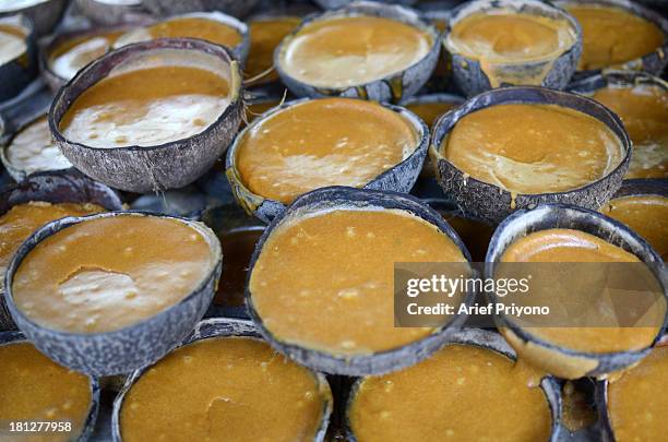 Halved coconuts make pots for setting brown sugar in a small factory in Slumbung Village. Most Indonesian people use brown sugar to sweeten foods and...