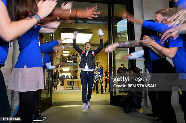 Jesse Green from London leaves with his iPhone 5S after being the second person to enter the Apple store after they went on sale in central London on...