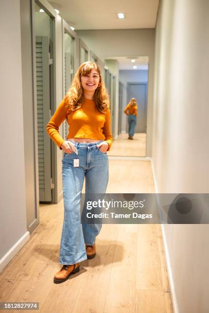 un accro du shopping porte une paire de jeans à pattes d’éléphant - pantalon-à-pattes-déléphant photos et images de collection