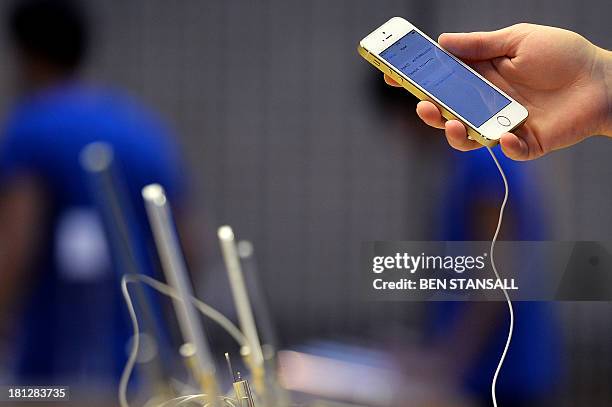 An employee prepares a display iPhone 5S's at the Apple store in preparation for opening ahead of the iPhone 5S and 5C going on sale in central...