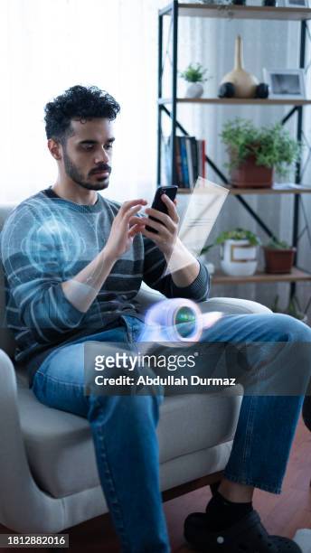 young man uses artificial intelligence at home concept photo - smartphone hologram stockfoto's en -beelden