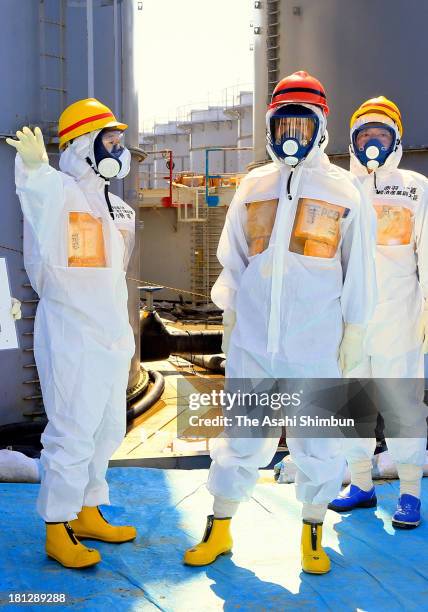 Prime Minister Shinzo Abe, in red helmet, listens to an explanation about the Alps water decontamination system at the Tokyo Electric Power Co...