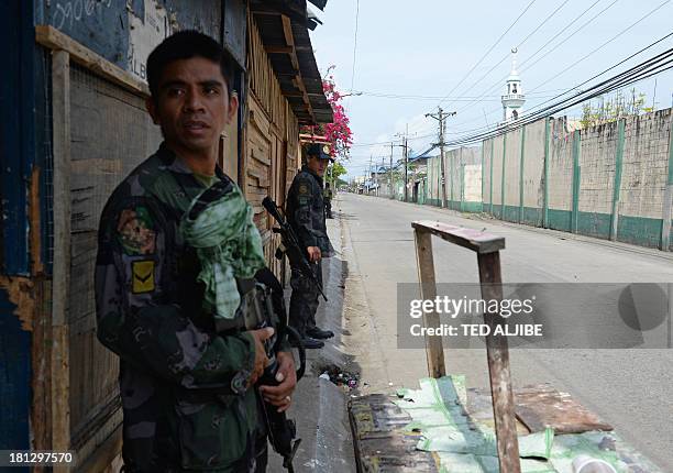 Philippine policemen man a checkpoint near the site of the stand-off between government forces and remnants of Muslim rebels in Zamboanga on the...