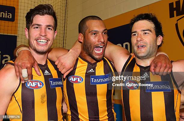 Ben Stratton, Josh Gibson and Jordan Lewis of the Hawks sing the song in the rooms after winning the AFL First Preliminary FInal match between the...