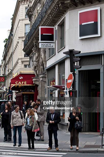 Pedestrians cross a road outside a Societe Generale SA bank branch in Paris, France, on Thursday, Sept. 19, 2013. Bank of France General Council...