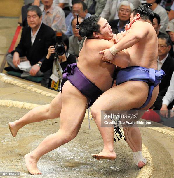 Chiyotairyu pushes out Okinoumi during day five of the Grand Sumo Autumn Tournament at Ryogoku Kokugikan on September 19, 2013 in Tokyo, Japan.
