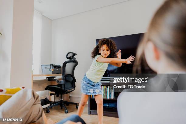 girl playing guessing game with her family at home - pantomime stock pictures, royalty-free photos & images